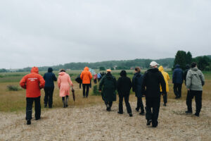 Policylabb Storkriket – människor går i regn vid våtmark